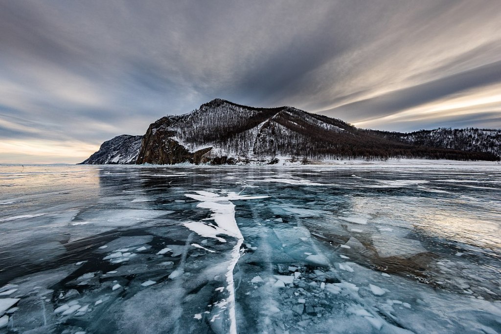 Frozen Lake Baikal in Russia. A mountain is shown in the background.